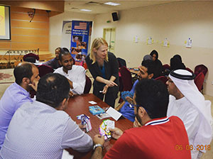 Megan Calvert talks to a group of men at a table
