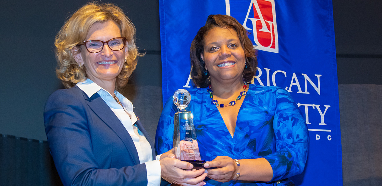 Diana Burley giving an award to professor