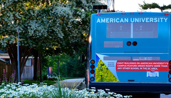 The back of the American University shuttle bus with white daisies to the left
